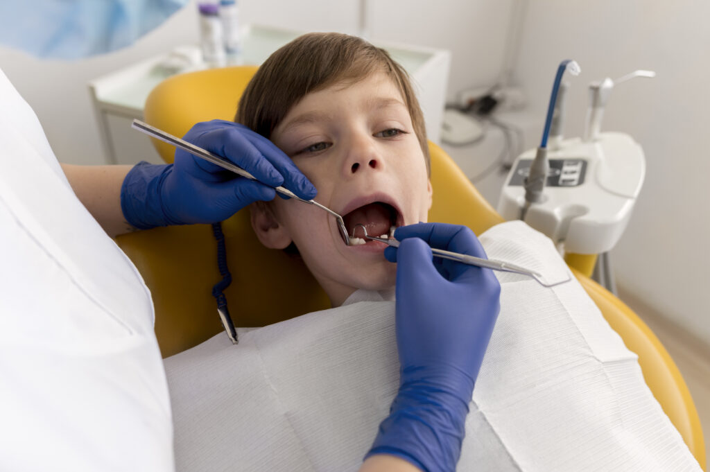 Pediatric dentist cleaning a child's teeth at Ocean Spray Dental, Gig Harbor, WA