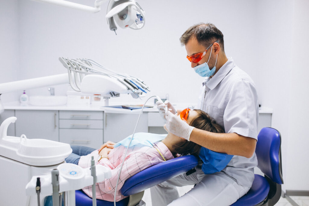Dentist performing restorative dentistry, relieving tooth pain in a modern treatment room at Ocean Spray Dental, Gig Harbor
