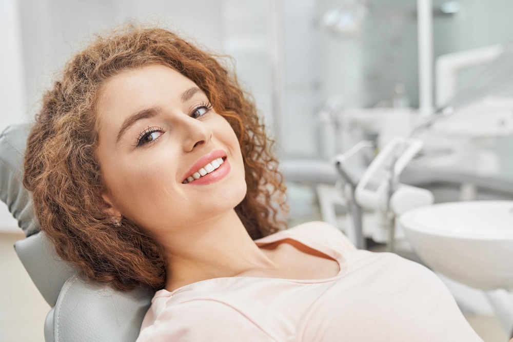 Patient smiling in a dental chair during a routine dental checkup