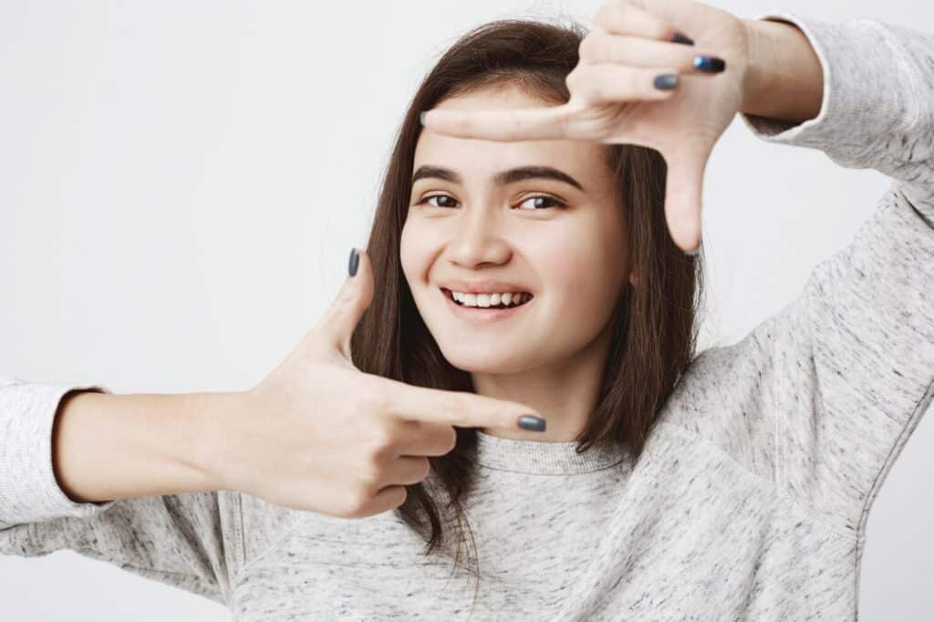 Smiling woman framing her teeth to highlight her smile