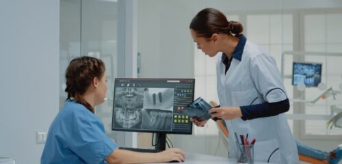 Dental professionals reviewing digital dental scans on a computer monitor